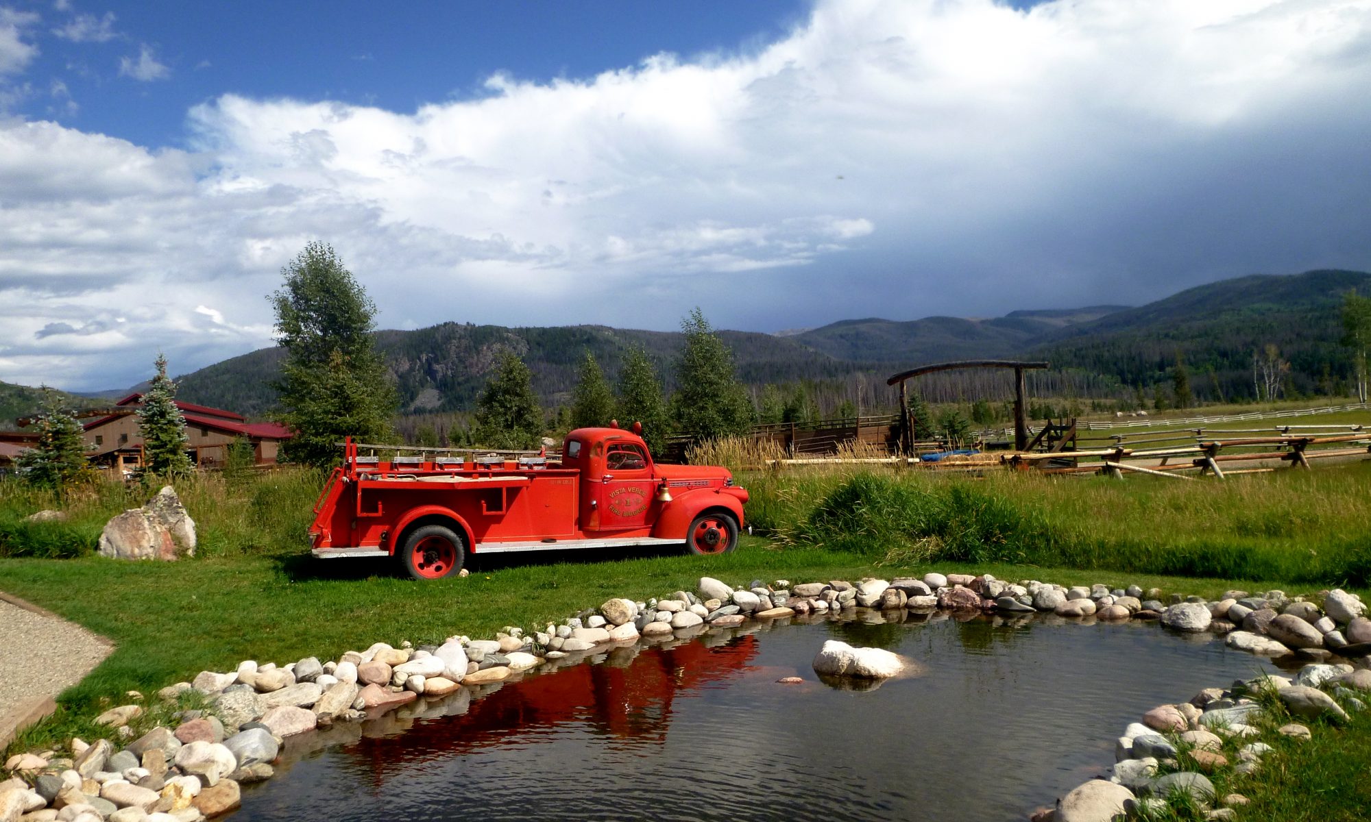 Old fire truck in front of pond